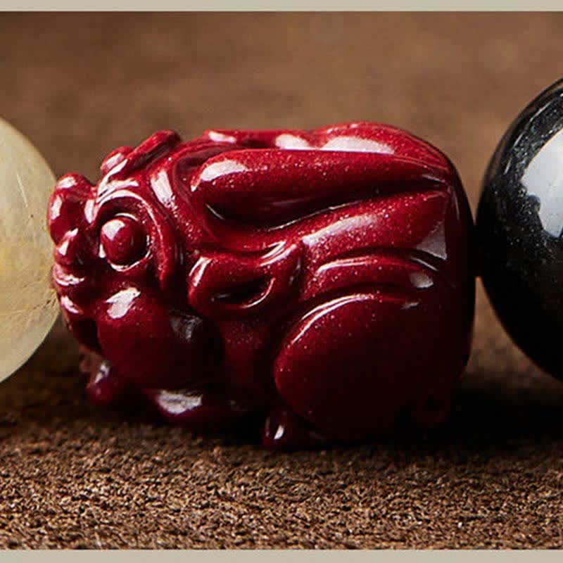 Gold Sheen Obsidian Pixiu Bracelet – macro red cinnabar pixiu carving with glossy texture and detailed facial features