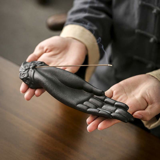 Buddha Hand Incense Burner – cradled by hands in traditional dress, burning incense with smoke curling, spiritual