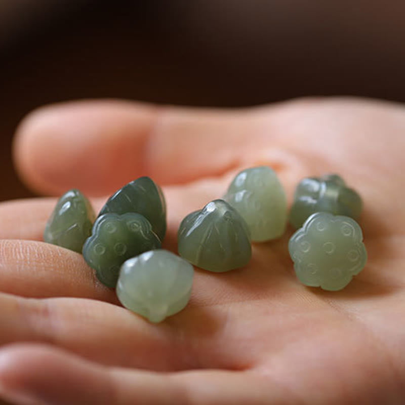 Jade Peace Buckle Lotus Necklace – Multiple carved lotus pod jade pendants resting in open palm, jade beads
