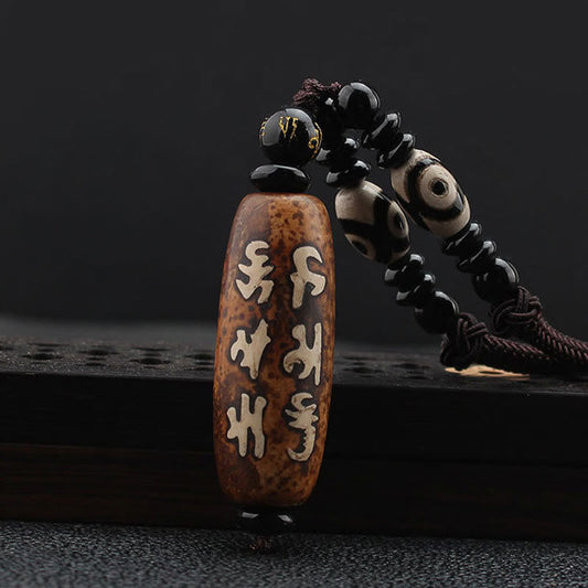 Dzi Bead Necklace – Mantra-engraved brown agate pendant with eye-pattern dzi beads on dark cord, spiritual