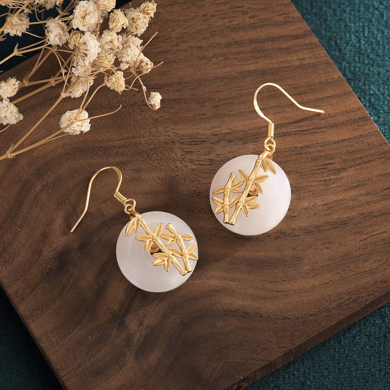 FengShui White Jade Fortune Earrings on wooden board with dried flowers