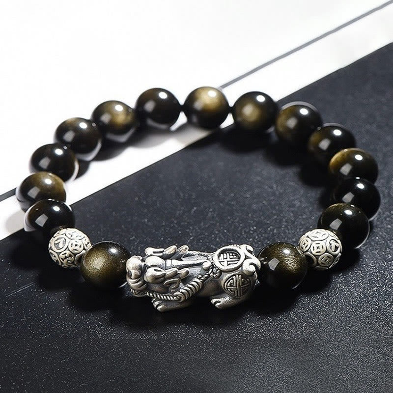 Gold Sheen Obsidian PiXiu Bracelet – Close-up of black beads with silver PiXiu and coin beads on dark surface