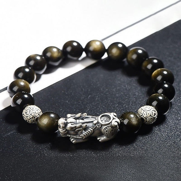 Gold Sheen Obsidian PiXiu Bracelet – Close-up of black beads with silver PiXiu and coin beads on dark surface