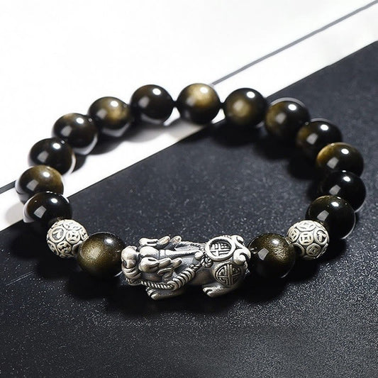 Gold Sheen Obsidian PiXiu Bracelet – Close-up of black beads with silver PiXiu and coin beads on dark surface