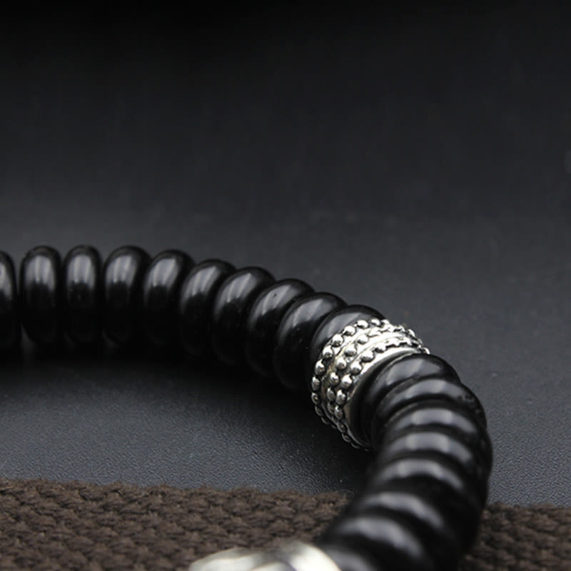 Om Mani Padme Hum Coconut Shell Bracelet – diagonal close-up with silver spacer bead