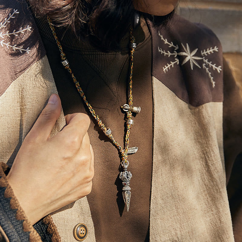Dorje Vajra Pendant – Worn close-up with embroidered vest in warm sunlight, ethnic spiritual jewelry