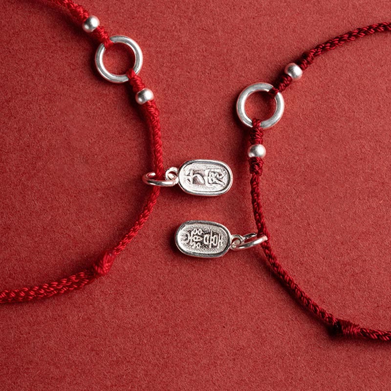 Sterling Silver Lotus Peace Buckle Red String Bracelet – Flat-lay overhead view of two matching red cord bracelets with silver adjustable rings and fortune charms