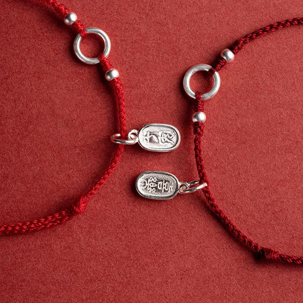 Sterling Silver Lotus Peace Buckle Red String Bracelet – Flat-lay overhead view of two matching red cord bracelets with silver adjustable rings and fortune charms