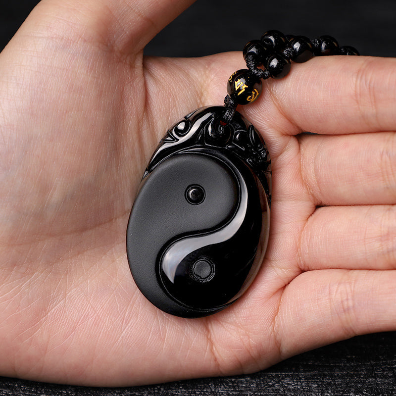 Black Obsidian Yin Yang Pendant Necklace – Obsidian Yin-Yang amulet in palm, hand scale reference, spiritual jewelry