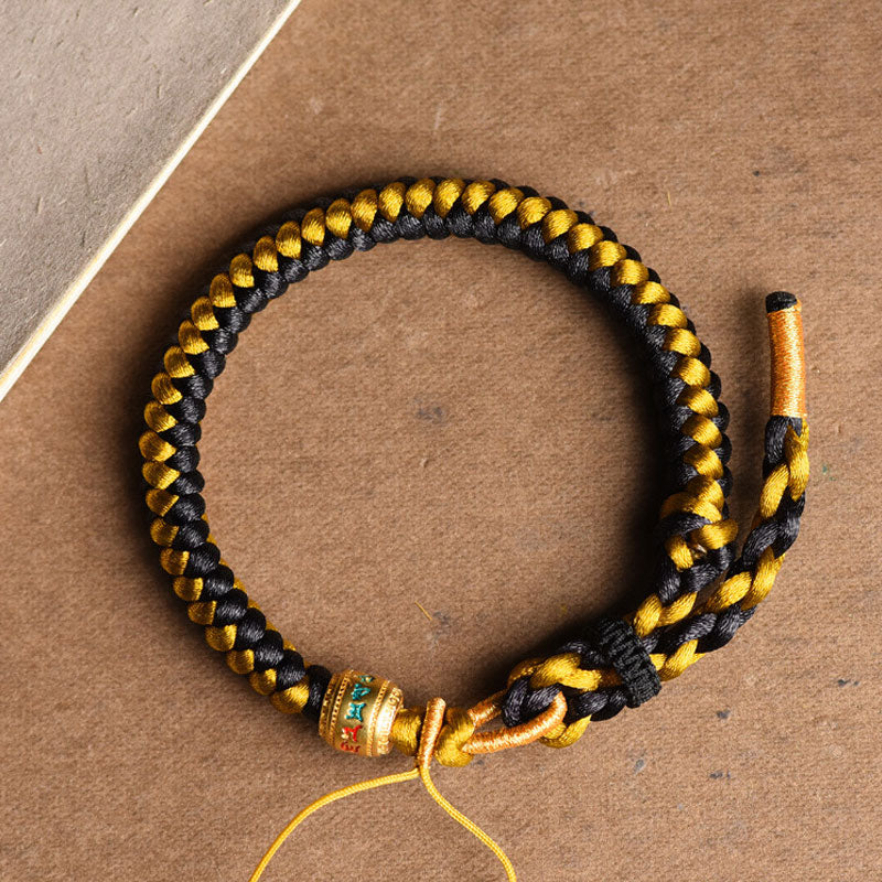 Tibetan Black Gold Dragon Scale Bracelet – overhead flat-lay on kraft paper, braided black and gold cords, handmade bracelet Image principale du produit