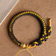 Tibetan Black Gold Dragon Scale Bracelet – overhead flat-lay on kraft paper, braided black and gold cords, handmade bracelet