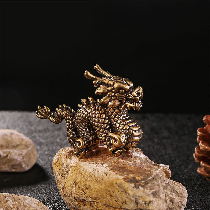 Auspicious Brass Dragon Decoration - Three-quarter profile of coiled dragon on stone with river pebbles, luck charm