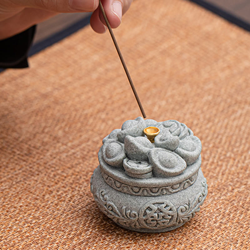 Fu Character Sandstone Incense Burner – hand inserting incense stick into gold holder, sandstone incense burner