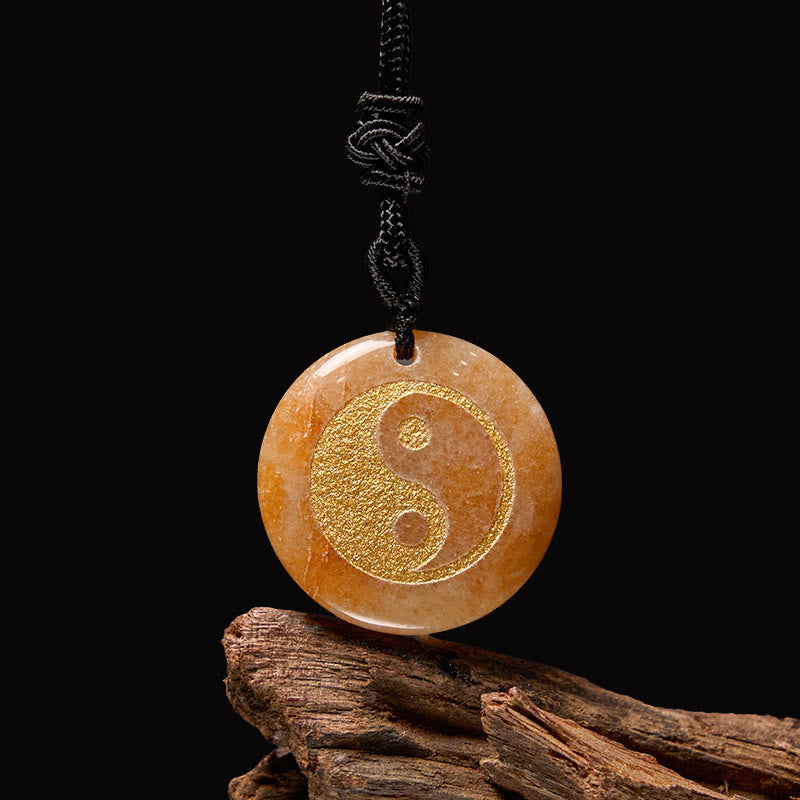 Yin Yang Crystal Necklace – Peach-orange natural stone pendant with gold yin-yang symbol on black cord, polished stone on wea