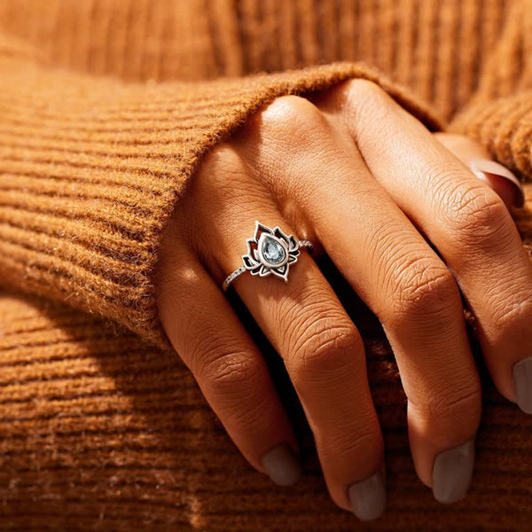 Lotus Zircon Ring – clear stone lotus on hand against knit sweater, blessing ring