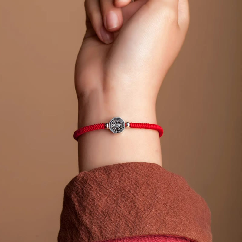 925 Sterling Silver Yin Yang Bagua Cinnabar Bracelet – Red cord Bagua bracelet on wrist, close-up wear shot, beige background