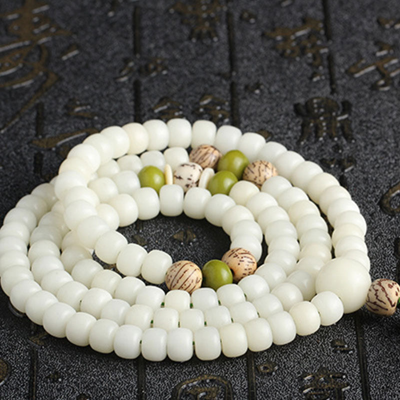 Bodhi Seed Lotus Mala - coiled on stone with Chinese calligraphy, cultural authenticity, zen aesthetic