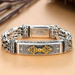 Vajra Dorje Copper Balance Bracelet - twisted braided copper chain bracelet with gold-tone vajra dorje centerpiece, oxidized silver finish, heavy Byzantine links, flat lay on warm wood background, front view
