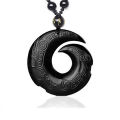 Black Obsidian Ice Obsidian Pendant Necklace – Black polished obsidian spiral carved pendant with intricate Greek key and cloud scroll relief patterns, gold character accent bead, black braided cord, white studio background, obsidian healing crystal jewelry
