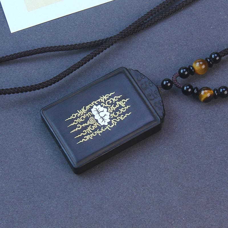 Ebony Wood Lotus Pendant – Three-quarter view on dark fabric, gold yantra, Spiritual