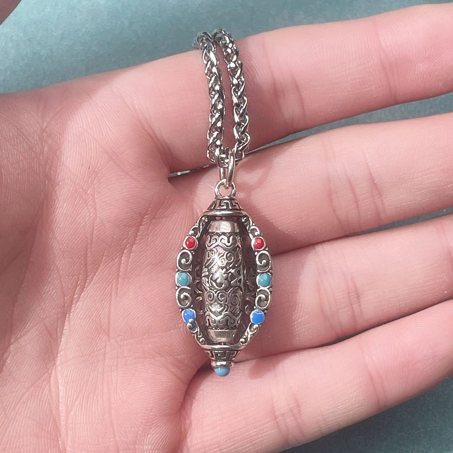 Tibetan Om Mani Padme Hum Pendant Necklace – Hand-held close-up revealing pendant size and metal filigree craft details