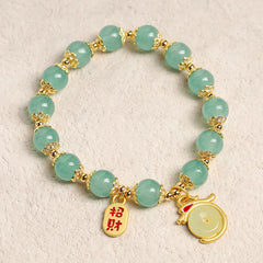 Red Agate Aventurine Dragon Bracelet – Top-down view of green bead bracelet with dual gold charms, Cultural