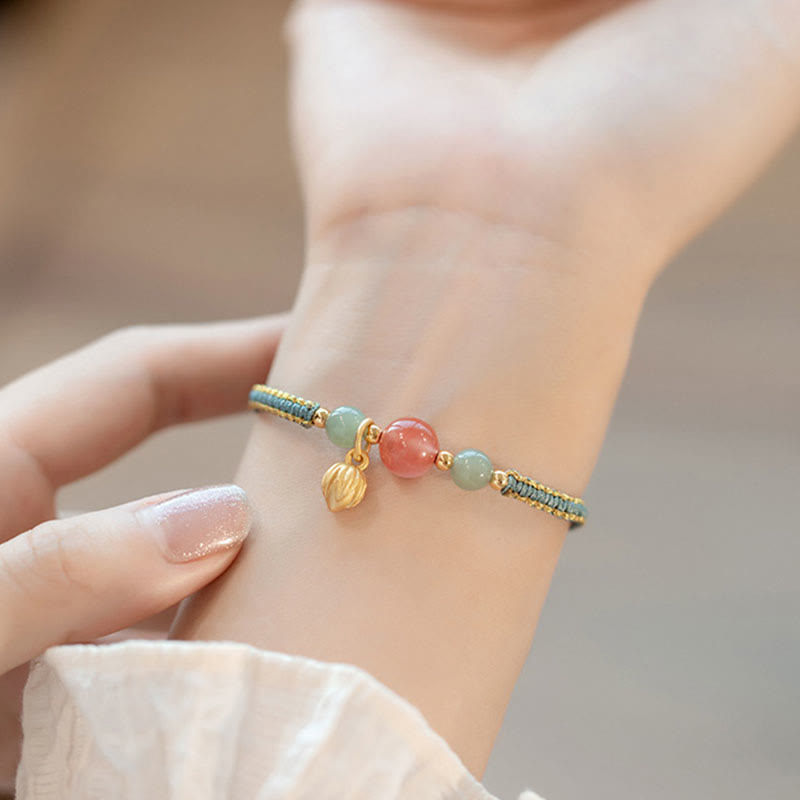 Red Agate Jade Lotus Bracelet – sage green gold cord with pink center and green side beads, lotus charm, lifestyle wrist close-up