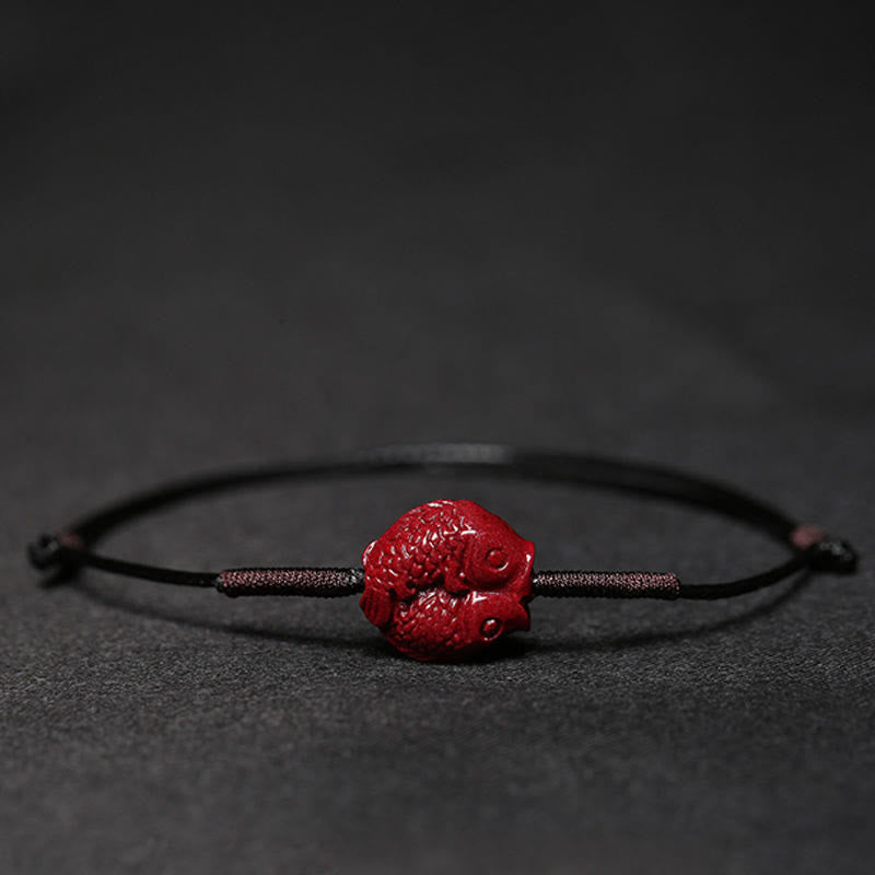 Cinnabar PiXiu Lotus Koi Fish Blessing Braid Bracelet – close-up koi fish pair on black cord showing scale texture, detailed cinnabar carving