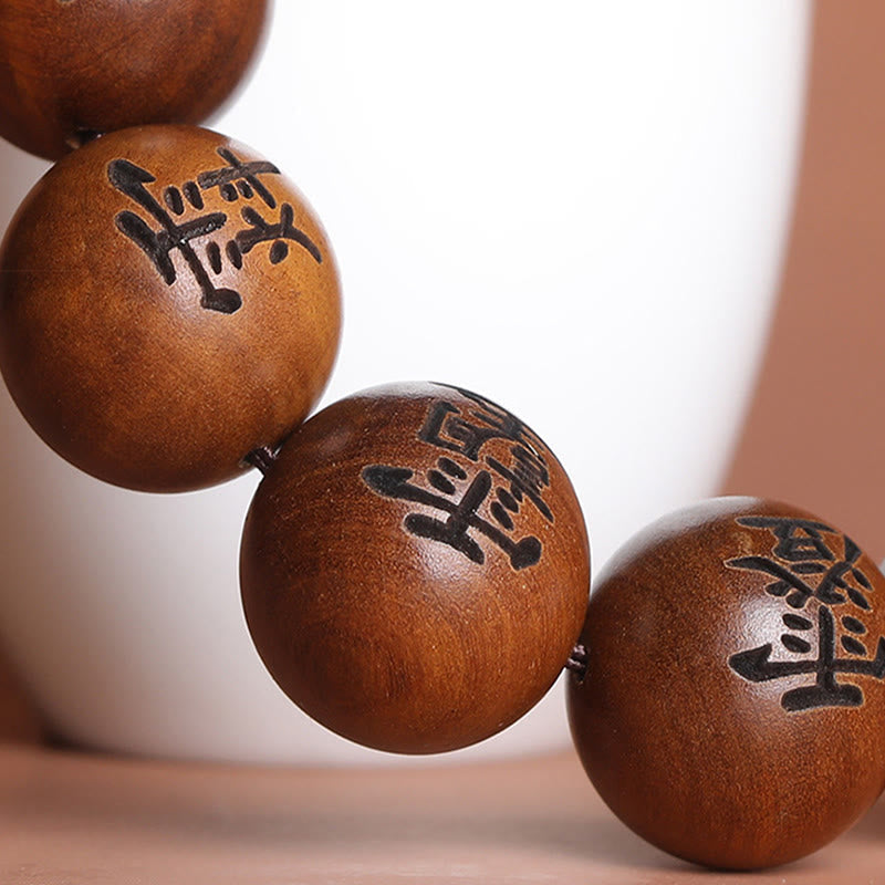 Lightning Struck Jujube Wood Taoist Bracelet - Close-up of four engraved wood beads with Chinese calligraphy, wooden talisman beads