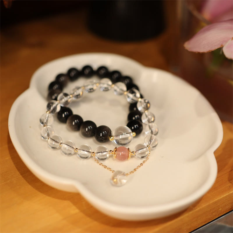 Yin Yang Obsidian Crystal Bracelet - Clear and black beaded pair on ceramic dish, crystal bracelet set