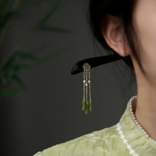 Peridot Ebony Wood Hairpin, styled in hair bun side profile view with green tassel