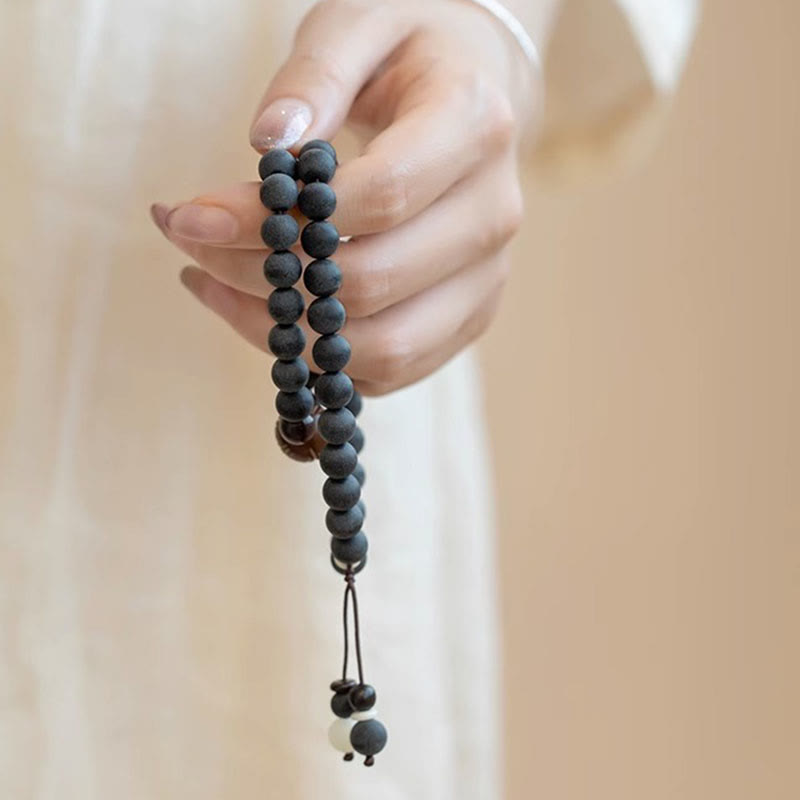 Tibetan Cypress Bodhi Lotus Bracelet - black mala with amber accent bead and tassel, meditative