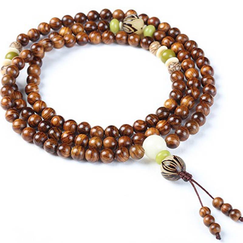 Tibetan Rosewood Bodhi Seed Mala Bracelet flat lay on white background, triple-wrap coil showing 108 beads with green jade accents and carved seed beads, polished wood grain texture, guru bead and tassel detail