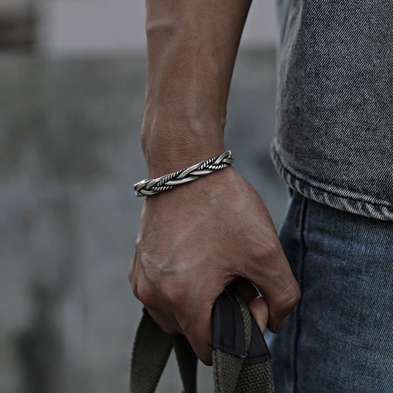 Viking twisted braided copper balance bracelet with multi-strand rope twist design oxidized silver finish worn on male wrist with gray t-shirt and blue denim