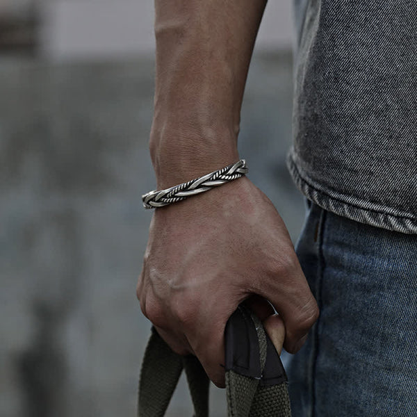 Viking twisted braided copper balance bracelet with multi-strand rope twist design oxidized silver finish worn on male wrist with gray t-shirt and blue denim
