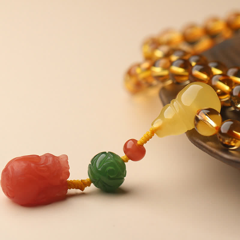Citrine Mala Bracelet – Citrine mala with amber peace buckle on warm background, charm detail