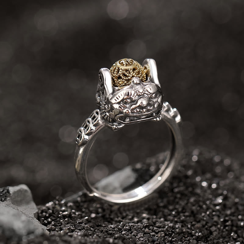 Sterling Silver PiXiu Wealth Ring – Silver ring with gold pixiu beast and coin orb on dark stone, feng shui