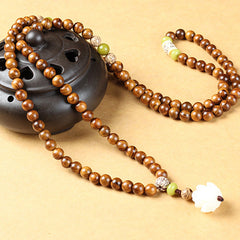 Rosewood Lotus Mala – prayer beads on ceramic incense burner with green jade markers, grounding
