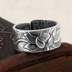 999 Silver Lotus Ring – 3/4 view on carved wood, interior sutra text visible