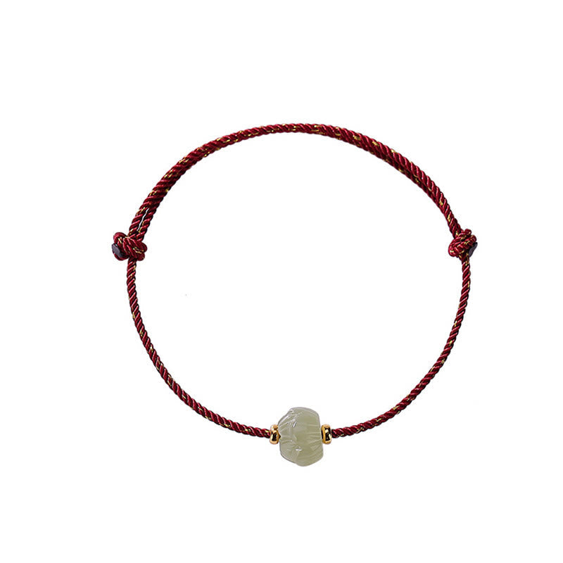 Hetian Jade Lotus Red String Bracelet - Top-down overhead on white, lotus jade with gold spacers, healing jewelry