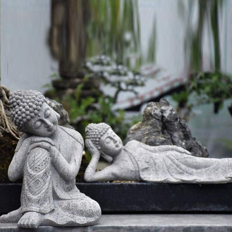 Tibetan Meditation Buddha Resin Decoration – two Buddha figures displayed among garden rocks, seated and reclining poses, blessing decor