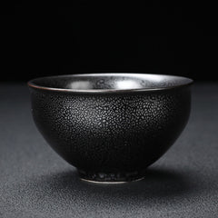 Gold Leaf Jianzhan Teacup – Hand holding jianzhan bowl with gold koi motif, kung fu tea set