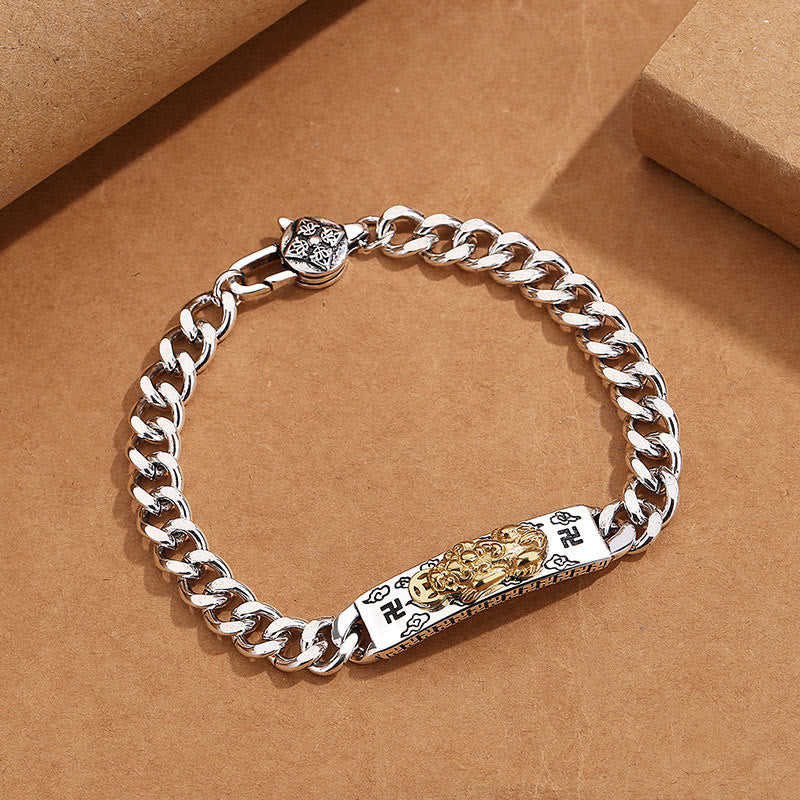 Om Mani Padme Hum PiXiu Swastika Wisdom Bracelet – silver Cuban chain with gold PiXiu centerpiece on brown surface