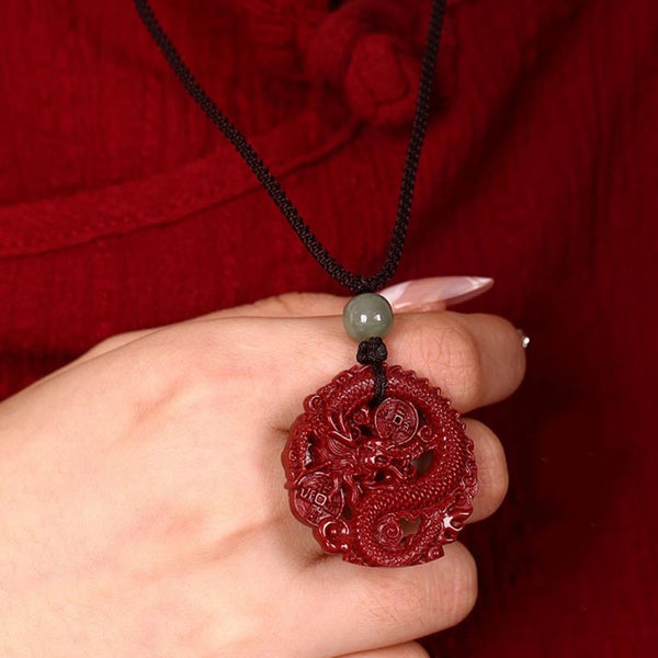 Cinnabar Hetian Jade Dragon Necklace - coiled dragon pendant in cupped hand, red silk setting