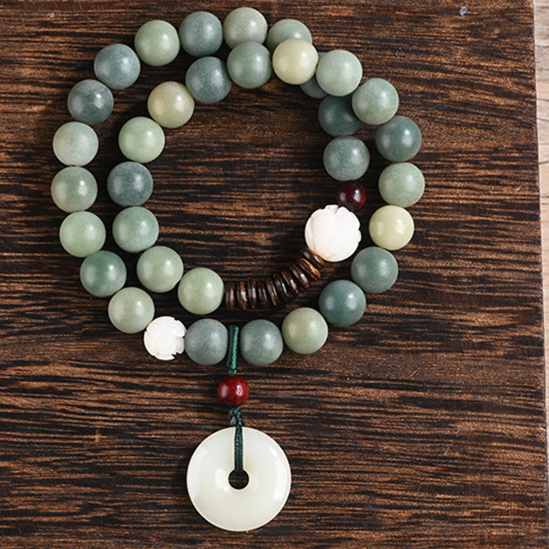Cyan Bodhi Seed Jade Peace Buckle Bracelet - jade-like beads and lotus carving on dark wood, clean product shot
