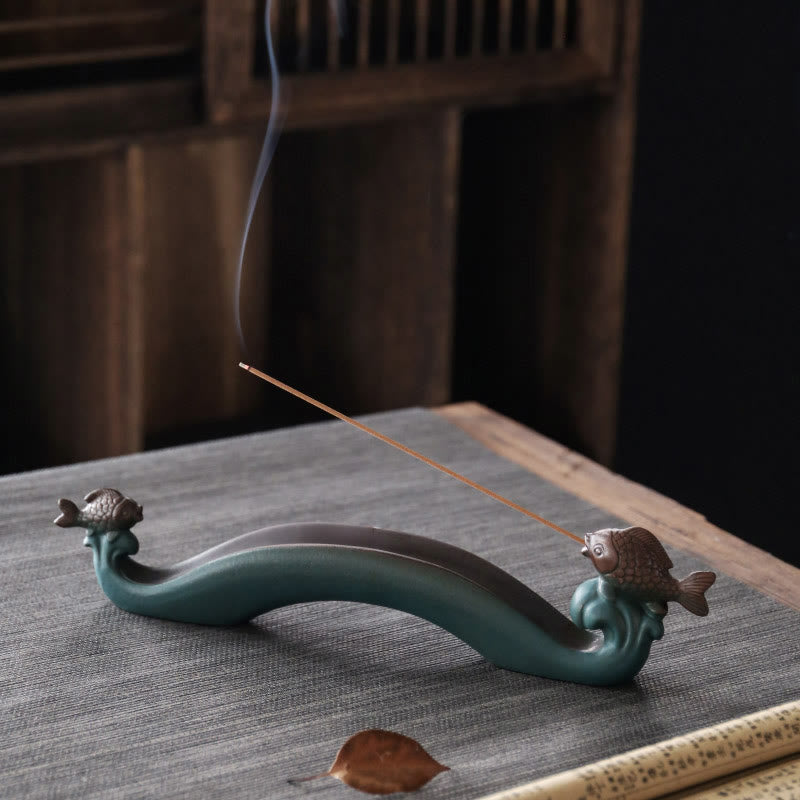 Double Koi Fish Mountain Incense Burner - teal wave holder with bronze koi and rising smoke on gray mat, koi incense burner