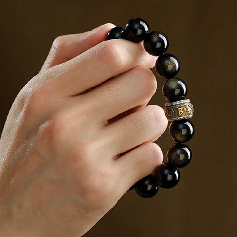 Gold Sheen Obsidian Pixiu Bracelet – hand holding close-up of gold sheen obsidian and bronze om mani padme hum spacer