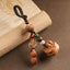 Peach wood Feng Shui keychain with peanut charm, lotus bodhi beads and carved persimmon pendant on vintage book