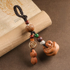 Peach wood Feng Shui keychain with peanut charm, lotus bodhi beads and carved persimmon pendant on vintage book
