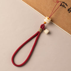 Bodhi Maneki Neko phone strap in wine red cord with carved cat bead charm and wristlet loop